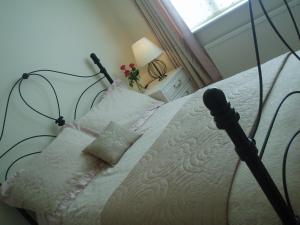 a bedroom with a white bed with a black frame at Copper Beech Rooms in Newquay
