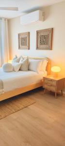 Un dormitorio con una cama con almohadas y una mesa. en Direct Ocean Front Apartment, en Redcliffe