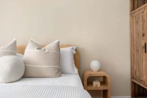 Un dormitorio con una cama con almohadas blancas. en Direct Ocean Front Apartment, en Redcliffe 33 fotos más