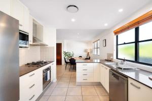 a kitchen with white cabinets and a large window at Inner City Townhouse in Brisbane