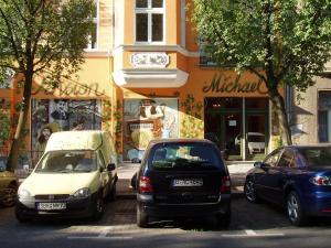 eine Gruppe von Autos, die an der Straßenseite geparkt sind in der Unterkunft Pension Michael in Berlin