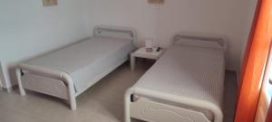 two beds in a small room with a table at Filina's Studio in Maltezana