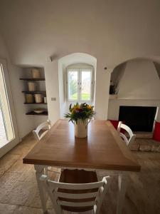 a dining room with a wooden table with flowers on it at Trulli Capomazza in Noci