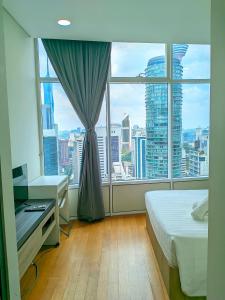 a bedroom with a large window with a view of a city at Sky Suites KLCC Kuala Lumpur LB in Kuala Lumpur +107 photos