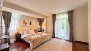 a bedroom with a large bed and two windows at Private Pool Villas Sukhumvit 26 Near BTS Phrom Phong and EmSphere in Bangkok +104 photos