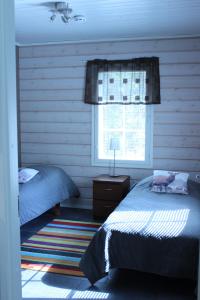 1 dormitorio con 2 camas y ventana en Rukan Mökit en Ruka