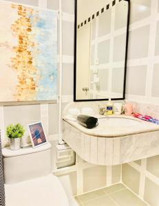 a bathroom with a sink and a mirror and a toilet at Private Pool Villas Sukhumvit 26 Near BTS Phrom Phong and EmSphere in Bangkok