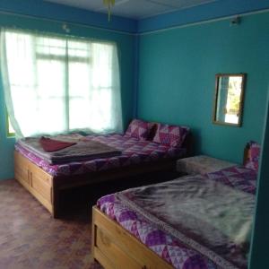 a bedroom with two beds and a window at Sai Lakshmi Homestay in Pedong