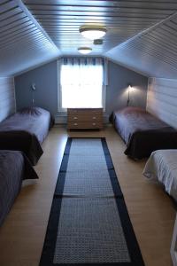 1 dormitorio con 2 camas, ventana y alfombra en Rukan Mökit en Ruka
