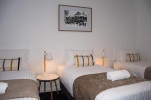 a room with two beds and a table with a lamp at Alpine Hotel Bright in Bright