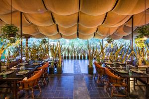 a restaurant with tables and chairs under a large umbrella at Movich Hotel Las Lomas in Rionegro