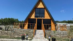 a wooden cabin with a gambrel roof at Nora's Chalet in Fshati i Ri