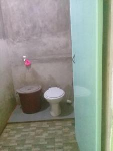 a bathroom with a toilet and a trash can at Bunda Homestay and Garden Warung 