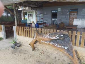 a wooden bench sitting in front of a restaurant at Bunda Homestay and Garden Warung 
