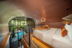 Una habitación con balcón con dos camas y bañera. en Seascape Resort & Spa Sanur by Ini Vie Hospitality, en Sanur 39 fotos más