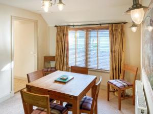 a dining room with a table and chairs and a window at Brandy Cottage - Ukc6855 in Millton of Clova