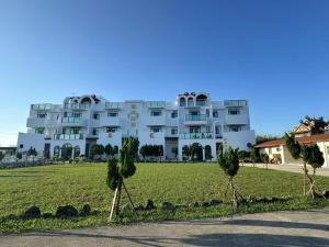 a large white building with trees in front of it at Long Xing B&B in Huxi