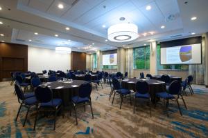 a conference room with tables and chairs and a screen at Coast Tsawwassen Inn in Delta