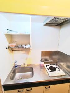 a small kitchen with a sink and a stove at 鹿鳴黄金1 in Nagoya