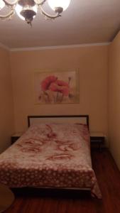 ザポリージャにあるApartment Lux on Prospekt Metallurgovのベッドルーム1室(ピンクの毛布とシャンデリア付きのベッド1台付)