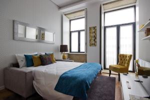 een slaapkamer met een groot bed en een stoel bij OHH -Porto 4 you- Deluxe Apartment With Free Parking in Porto