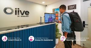 a man with a backpack looking at a computer at Olive Hotel Kundalahalli by Embassy Group in Bangalore +32 photos