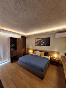 a bedroom with a large bed with blue sheets and yellow pillows at George Luxury Condo in Playa del Carmen +19 photos
