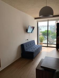 a living room with a blue couch and a large window at George Luxury Condo in Playa del Carmen +19 photos