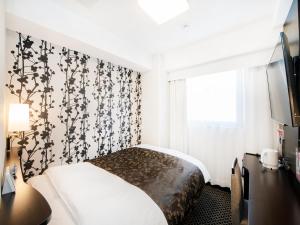 a bedroom with a bed with a black and white wallpaper at APA Hotel Hakata Higashihieekimae in Fukuoka