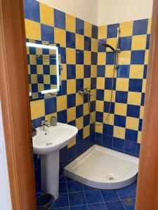 a blue and yellow bathroom with a sink and a shower at ED Living in Orikum