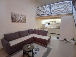 a living room with a brown couch and a kitchen at ED Living in Orikum +4 photos
