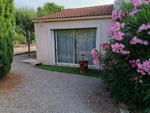a small house with a window and pink flowers at Chambre Le Luc en Provence in Le Luc