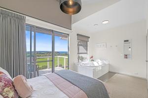 une chambre avec un lit, une baignoire et un lavabo dans l'établissement Luxurious 2-Bedroom Spa Apartment with Ocean Views, à Kronkup