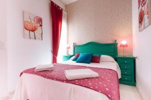 a bedroom with a bed with a green headboard at Singular Virgenes in Seville