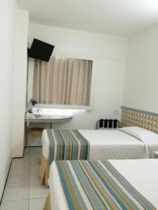 a hotel room with a bed and a table at Conect Smart Salvador by Accor in Salvador