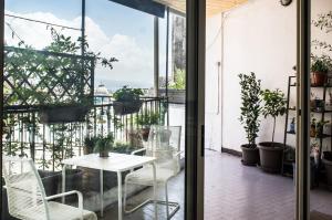 eine Terrasse mit einem weißen Tisch und Stühlen auf einem Balkon in der Unterkunft Taggarb in Neapel