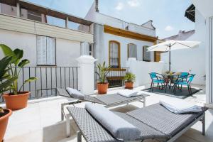 a patio with chairs and a table on a balcony at Singular Virgenes in Seville