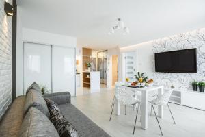 een woonkamer met een bank, een tafel en een tv bij Silver Apart Rzeszów in Rzeszów