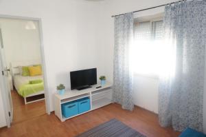 a living room with a television and a bed at Oriente DNA Studios II in Lisbon