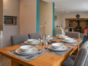 a wooden table with plates and wine glasses on it at Uk47757 - Rose Cottage in Launceston