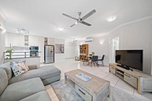 a living room with a couch and a flat screen tv at Beachside 2 bed 2 bath unit in Townsville
