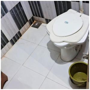 德瓦尔卡Hotel Yuvraj AC OR NON AC BOTH ROOM Dwarka Gujrat的浴室设有白色卫生间和绿色桶