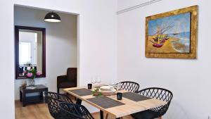a dining room table with chairs and a painting on the wall at Ifigenias apartment in Áyios Pétros +14 photos