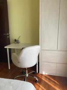 a white desk with a white chair next to a door at Palm Light Nusa Dua in Nusa Dua