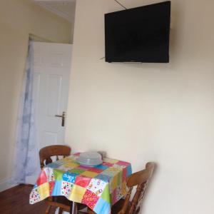 Lative في Lateeve: طاولة مع قطعة قماش ملونة وتلفزيون على الحائط