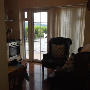 Lative في Lateeve: غرفة معيشة مع كرسي وباب زجاجي منزلق