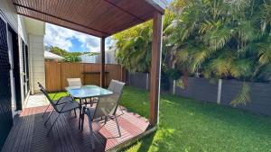 eine Terrasse mit einem Glastisch und Stühlen auf einer Terrasse in der Unterkunft Sienna Rise - Walk to Westfield sleeps 6 North Lakes in North Lakes