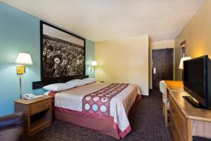 a hotel room with a bed and a flat screen tv at Super 8 By Wyndham Lexington Park/California Area in California