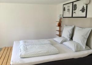 a white bed with white sheets and pillows at 2 quiet apartments in Copenhagen