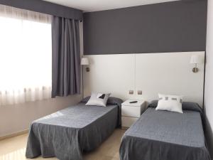 Posteľ alebo postele v izbe v ubytovaní Hotel Alguer